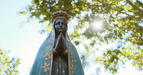 Sculpture of the image of "Nossa Senhora Aparecida" the patroness of Brazil. Image with gimbal on nature background on sunny day.