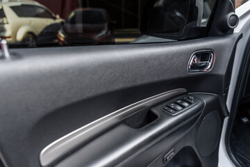Fototapeta na wymiar Mirror control knob and window control panel in a modern car. Automatic car window controls and details. Car door lock unlock button. Selective focus