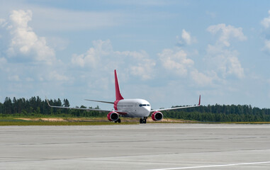 A passenger plane moves along the runway at the airport after landing