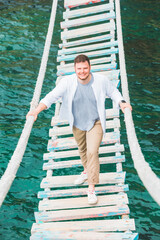 man walking by suspension bridge cross adriatic sea