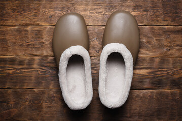 Galoshes shoes on the wooden brown floor background top view. Garden footwear.