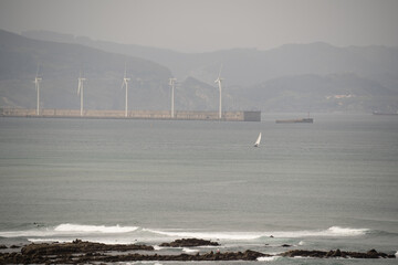 sailing in the morning with wind turbines behind