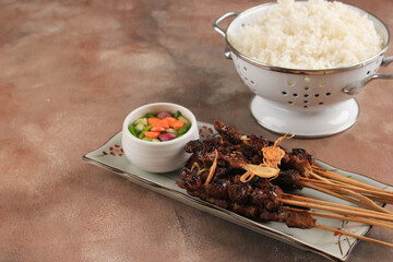 Selected Focus Sate Kambing (Lamb Satay) Served on Plate with White Rice and Chilli, Copy Space for Text
