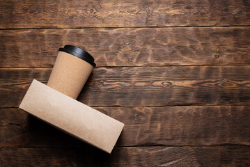 Mug of hot coffee in the cup holder on the wooden table flat lay background.