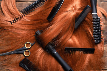 Hairdressing salon concept abstract background. Redhead women wig and combs on the hairdresser table flat lay background. - obrazy, fototapety, plakaty