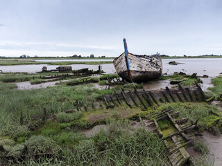 An abandoned boat decaying on the mud banks