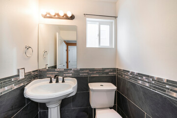 Small powder room interior with black and white tiles