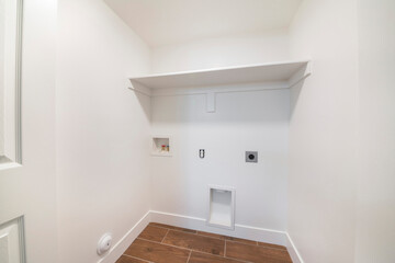 Clean small white empty laundry room with built in laundry connections