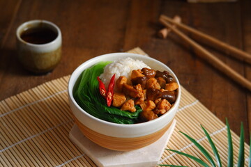 a bowl of rice with chicken meat and mushroom sauce 
