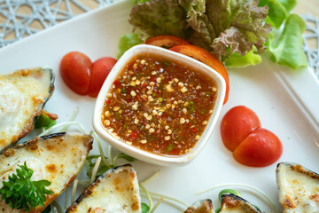 A traditional Thai style spicy seafood dipping sauce in white bowl which is served with cheese...
