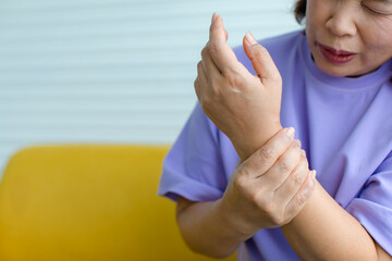 Woman using hand to hold other on arm with and feeling pain, suffer, hurt and tingling. Concept of Guillain barre syndrome and numb hands disease