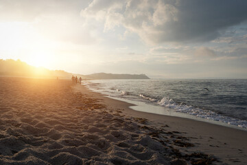 Strand mit Menschen zu Sonnenuntergang