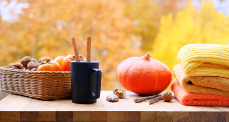 pumpkin, fruits on the table in the garden, beautiful blurred natural landscape, a cup of hot tea, coffee, seasonal concept, cozy autumn mood