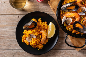 Traditional spanish seafood paella on wooden table. Top view