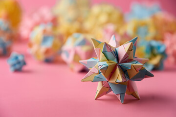 Set of multicolor handmade modular origami balls or Kusudama Isolated on pink background. Visual...