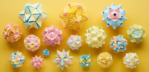 Set of multicolor handmade modular origami balls or Kusudama Isolated on yellow background. Visual...