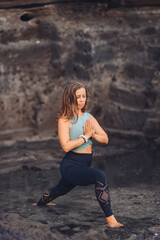 Fototapeta na wymiar European girl doing yoga on the background of rocks..