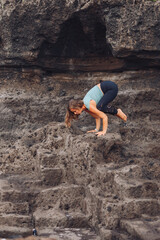 Obraz premium European girl doing yoga on the background of rocks..
