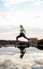 Girl doing yoga by the sea while standing in the water..