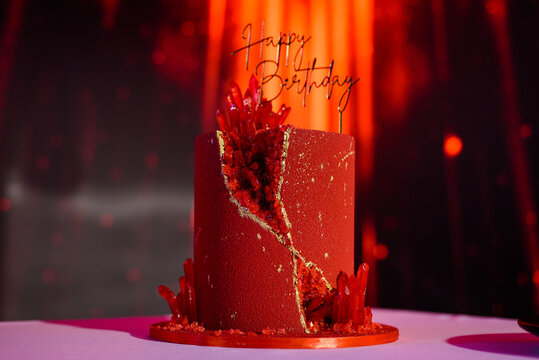 Red birthday cake with topper on a photo zone