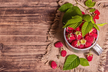 Fototapeta na wymiar Raspberries background. Ripe fruits in a vintage mug, rustic style