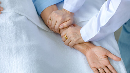 Doctor hold hand of patient on bed in hospital and checkup nervous system for cure and treatment. Concept of Guillain barre syndrome and numb hands disease or vaccine side effect