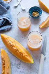 Fresh melon juice on the table, preparing melon  juice by raw ripe biological fruit, food background