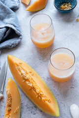 Fresh melon juice on the table, preparing melon  juice by raw ripe biological fruit, food background