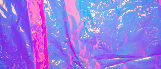 Holographic background. Real texture of cellophane film in bright colors.