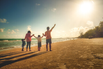Fototapeta premium Asian family vacation holiday on the beach in the sunset