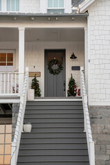 Gray staircase leading to a gray front door of a house