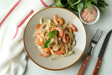 Concept of tasty eating with shrimp pasta on white textured table