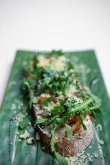 bruschetta or toast bread with salmon, arugula and cheese on white background