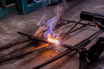 Close-up worker electric welding steel to connect the seam of metal partใ Blue fire flickers, orange sparks are flying