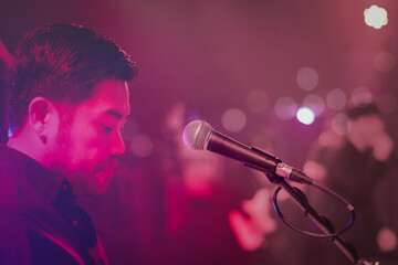 Obraz premium Close up of microphone for singer artist on stage with lighting bokeh at concert hall or conference room.