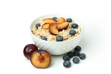 Bowl of oatmeal with tasty ingredients isolated on white background