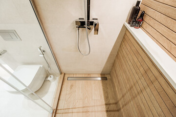 Modern wooden-effect bathroom with glass shower cabin and white toilit - 445547520