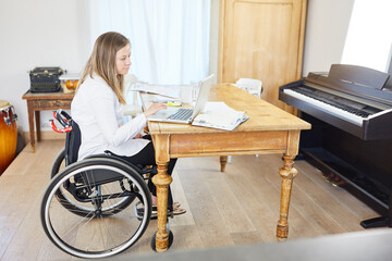 Business woman in wheelchair working online on laptop computer