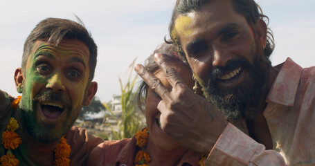 Closeup shot of Hispanic, South Asian and Caucasian male and female celebrating Holi festival