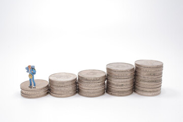 a mini people , Backpacker group standing on stack of coins.