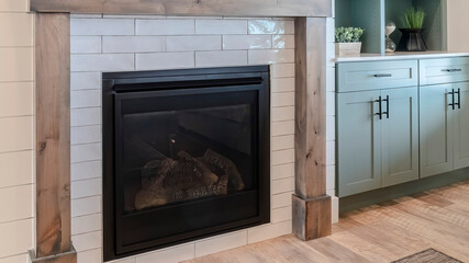 Fototapeta premium Pano Fireplace and cabinet inside home living room with wood floor and white wall