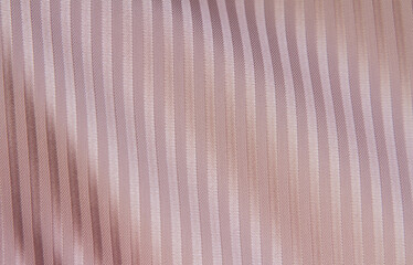Crumpled beige and pink striped fabric. Fabric texture,background for design.