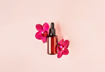 Decorative cosmetics composition of serum mockup bottle decorated with vivid pink orchid flowers on pastel background. Natural cosmetics concept. Flat lay style. Copy space.