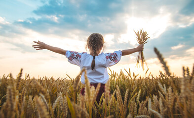Child in a wheat field. In vyshyvanka, the concept of the Independence Day of Ukraine. Selective...
