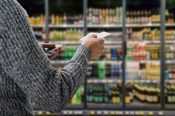 Young male customer making payment with credit card in grocery shop