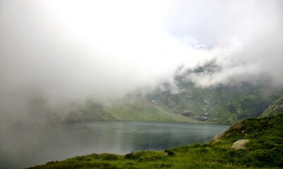 Lac de montagne dans les nuages - brouillard altitude - voyage aventure tourisme