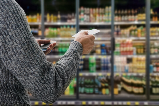 Young male customer making payment with credit card in grocery shop