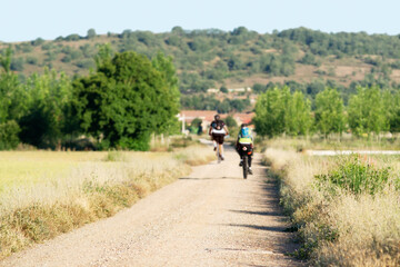 Way of St James , Camino de Santiago , pilgrims cycling  to Compostela , Leon, Spain , focus in foreground