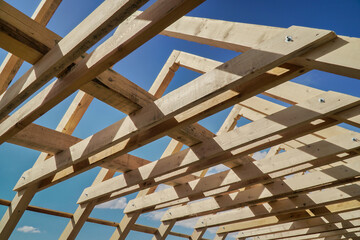 Roof construction. New residential construction home framing against a blue sky.