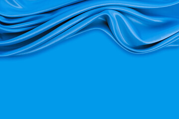 Beautiful elegant wavy blue satin silk luxury cloth fabric texture with monochrome background design. Copy space
